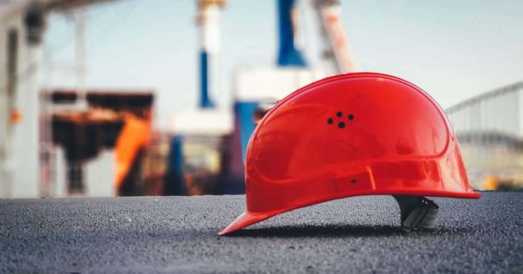 Close up workers' hardhat on the ground | Workers' compensation claim mistakes
