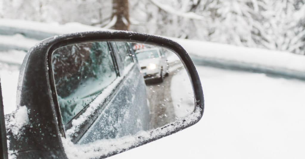 View from passenger side mirror while driving on snowy road | Winter Weather