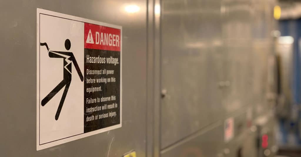 Machinery with electrical hazard warning label displayed | Workplace Hazards