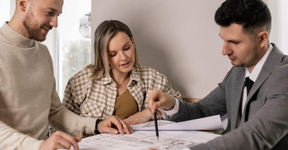 A young couple works with a lawyer and looks at various documents on estate planning