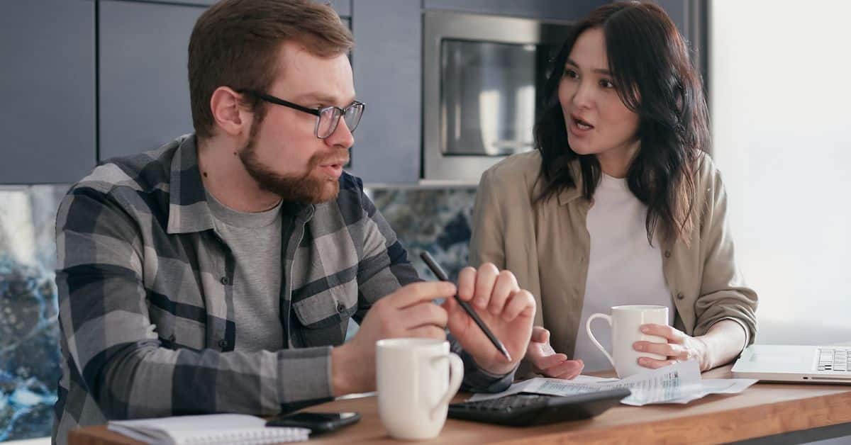 A frustrated man holding a pen talking with an upset woman