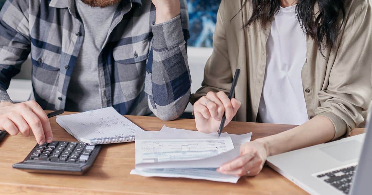 Couple sitting at a table with a notebook and calculator, Debts and Liabilities During Estate Administration