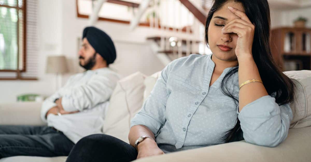 Frustrated woman and man sitting on opposite ends of a couch, Mistakes to Avoid in Estate Administration