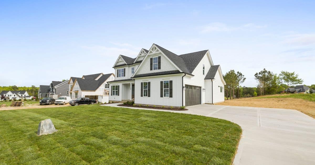 Two story white house at the end of a driveway