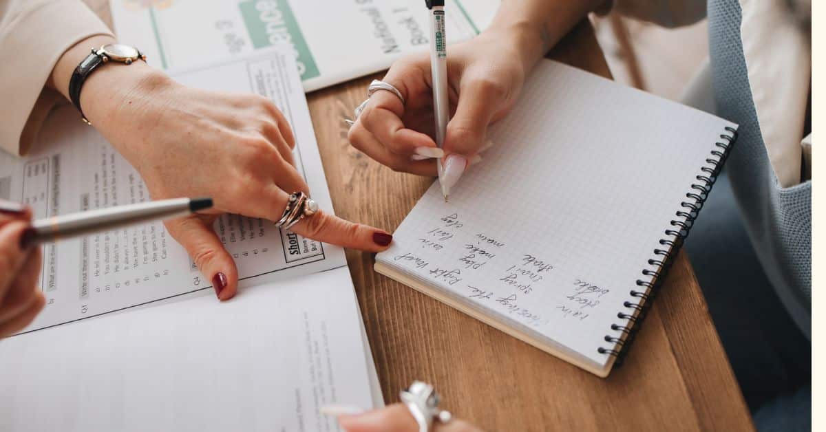 Woman writing in a notebook in pen while another woman's hand points at the notebook, Mistakes to Avoid in Estate Administration