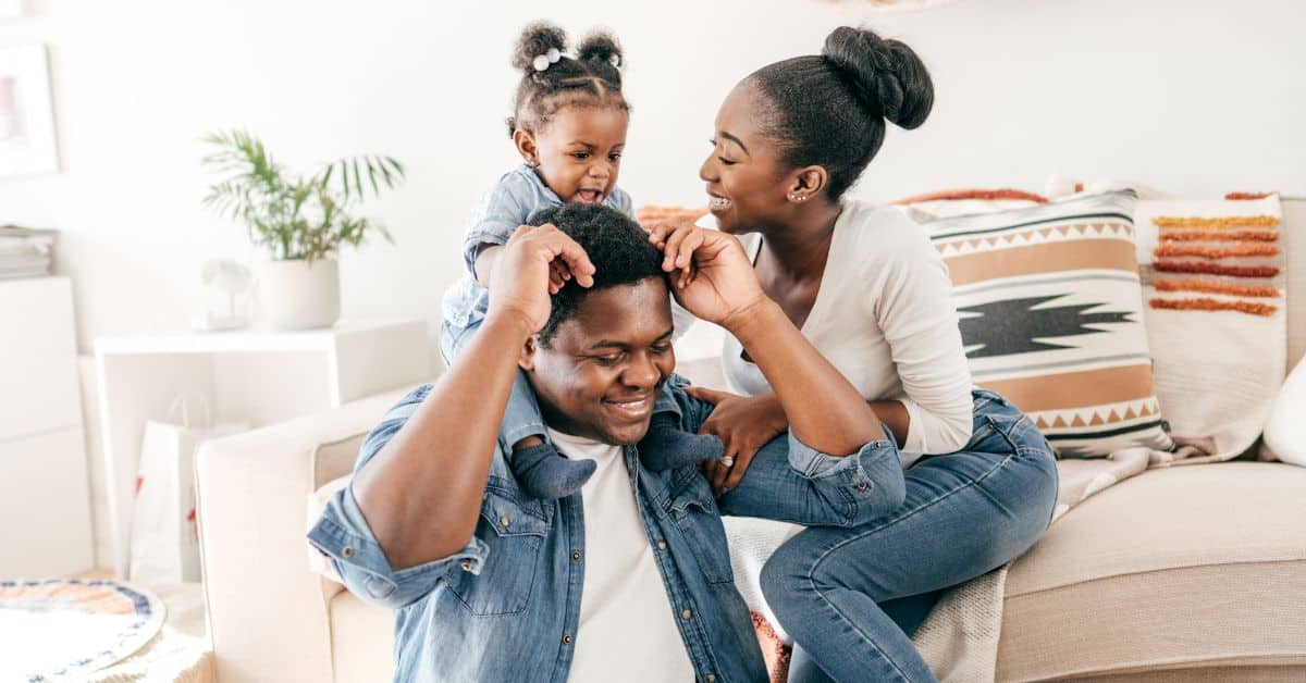 Happy family smiling and holding their daughter, Review Your Estate Plan